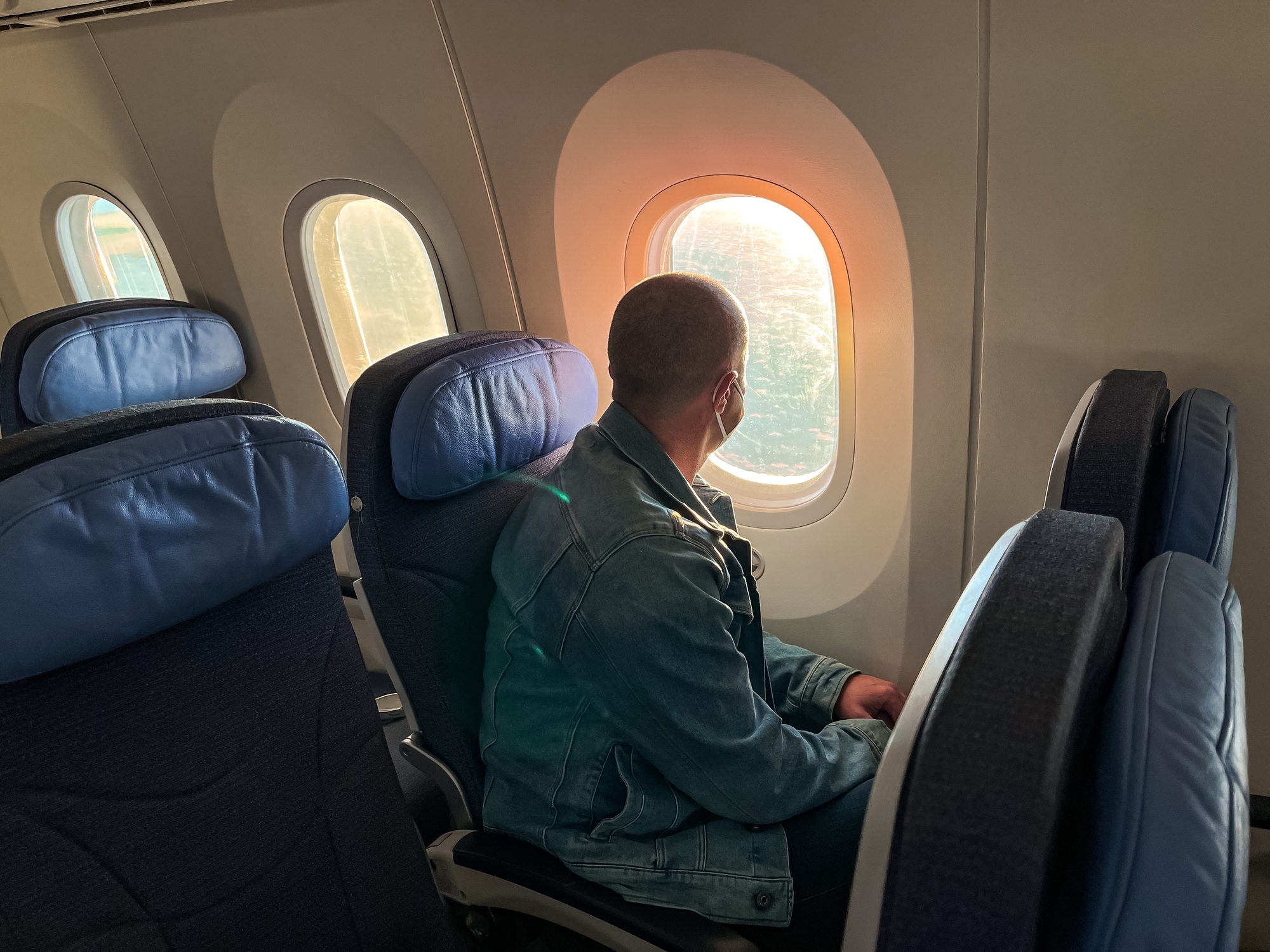 Man looking through a window traveling by plane, sitting, aircraft, airplane, seats
